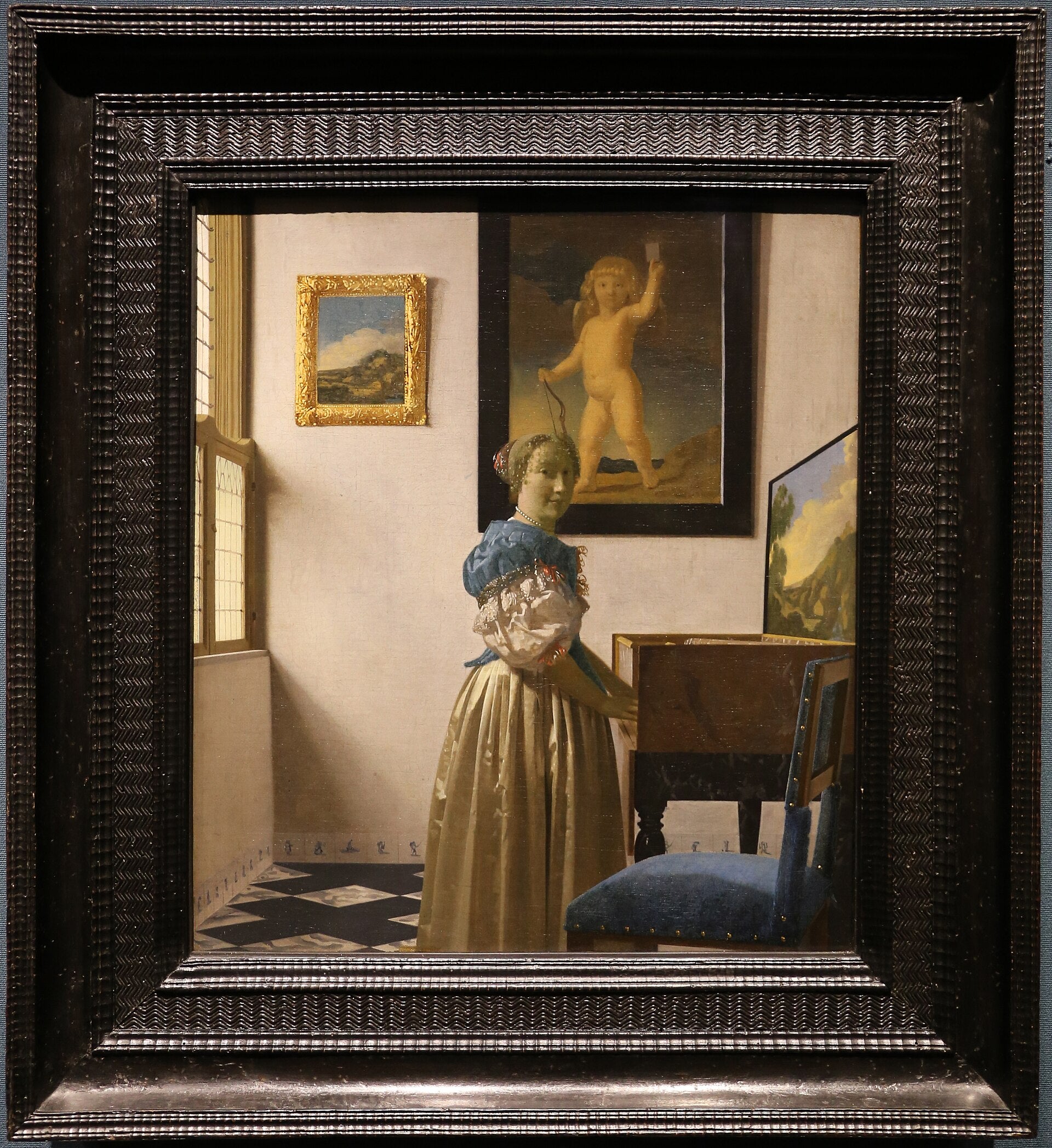 En dam stående vid virginalet - Johannes Vermeer